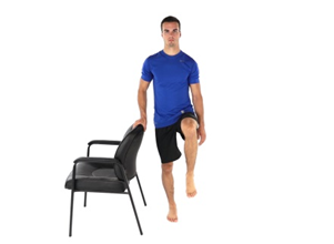 Marching on the spot whilst holding onto a chair.