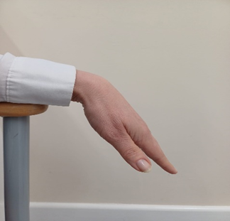 Wrist stretch, Place your forearms on the arms of a chair with your hands and wrists free over the edge. Palms down, fingers relaxed.