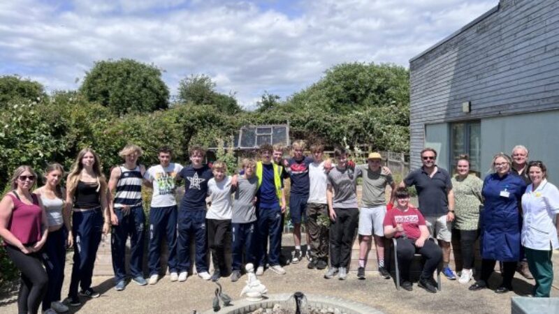 Volunteers and staff gathered in the garden at Donald Wilson House