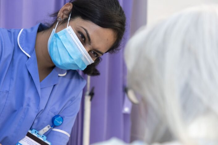 Nurse with mask smiling at patient