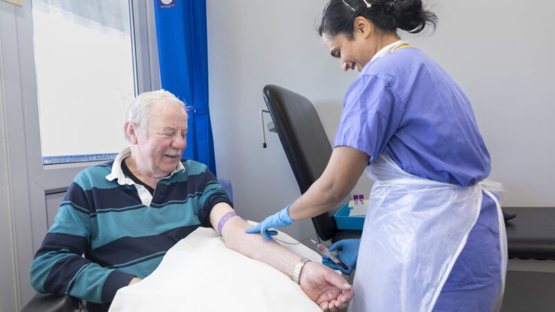 Clinician taking blood from patient