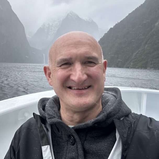 Professor Giles Critchley smiling at the camera while on a boat