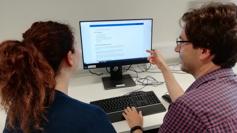 Two people sitting at a computer in the Health Information Point