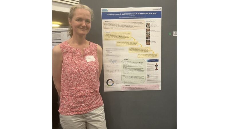 Katie standing next to her poster at the Sussex Clinical Academic Conference